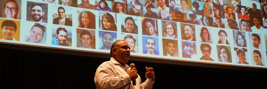 Professor Rayid Ghani speaking in front of a screen with a photo montage